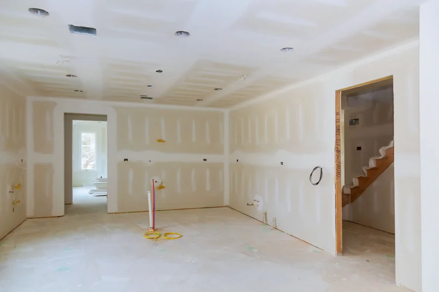 Room with freshly taped drywall seams across the ceiling and walls
