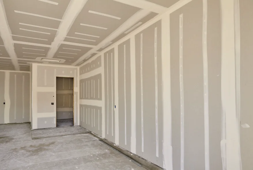 New construction room with drywall hung and taped on the walls and ceiling