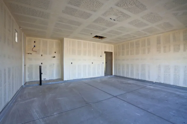 Garage with newly hung and taped drywall on the walls and ceiling