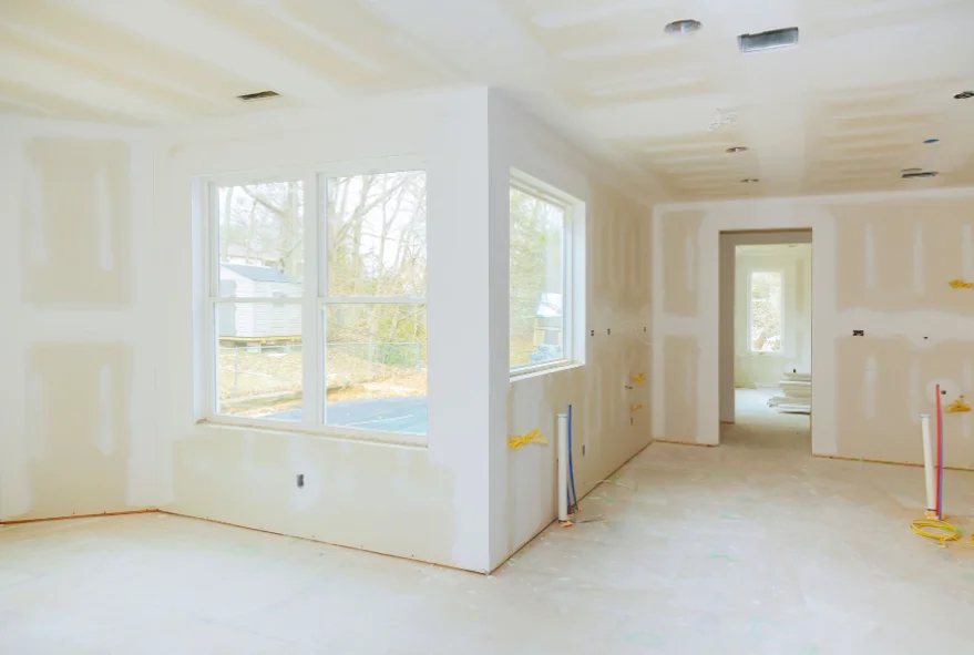 Remodeled room with new drywall around the windows ready for finishing